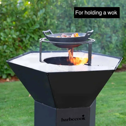 Black hexagonal Barbecook Dynamic Centre outdoor grill with fire and cast iron pan on wok and Dutch oven holder stand