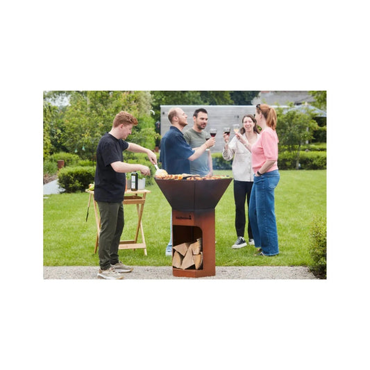 Rust-colored corten steel outdoor grill with conical cooking chamber and built-in wood storage compartment by barbecook