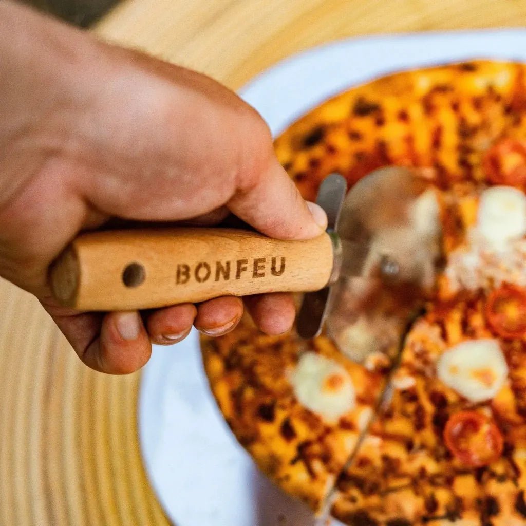 Wooden-handled bonfeu pizza cutter with engraved brand name and stainless steel wheel for slicing pizzas