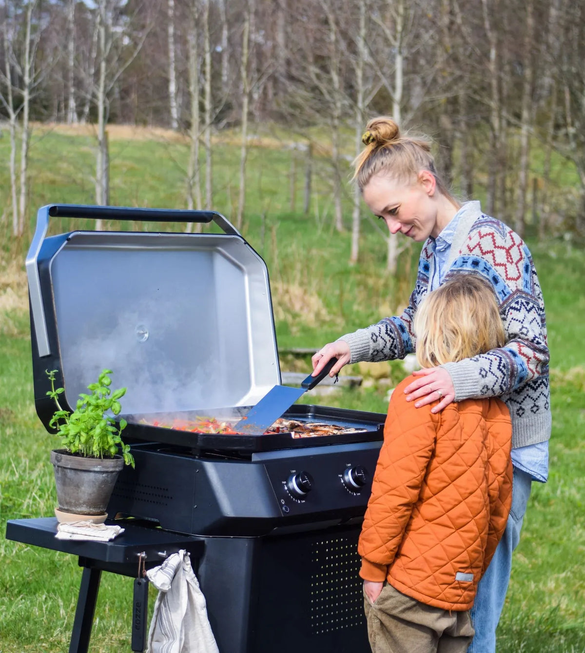 Black Cozze G-800 plancha gas grill with silver lid and control knobs featuring 3 gas burners for outdoor cooking