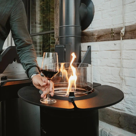 Black cylindrical Enders NOVA LED flame patio heater with glass fire bowl and visible flame for outdoor use