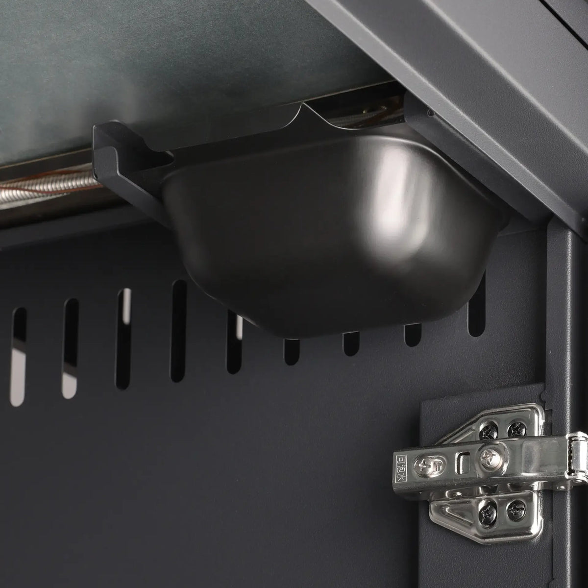 Black plastic catch mechanism attached to metal frame of grllr prime g3s 3 burner gas barbecue with side burner