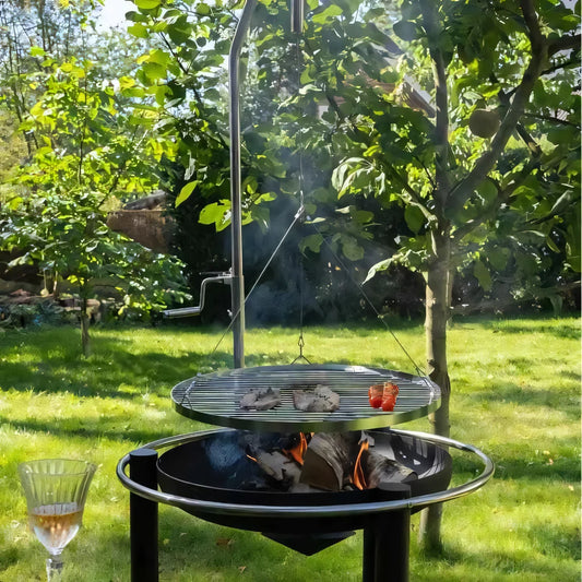 Silver-framed height adjustable grill with round wire mesh cooking surface over charcoal in heat pendal fire bowl base