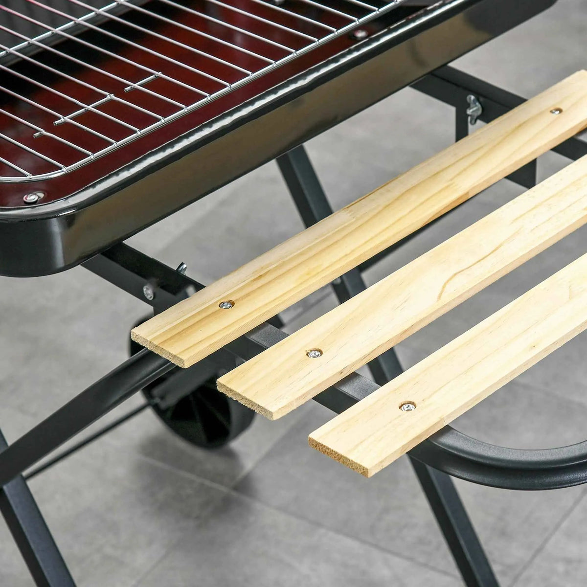 Three light-colored wooden slats with metal fasteners on the outsunny charcoal bbq grill trolley with wheels in black red