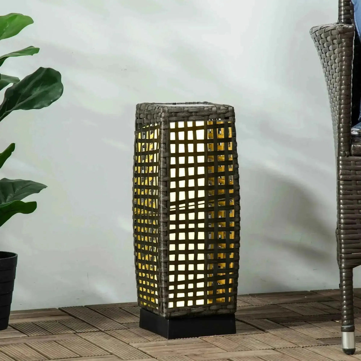 Outsunny outdoor rattan solar lantern with a dark gray woven wicker frame emitting warm yellow light