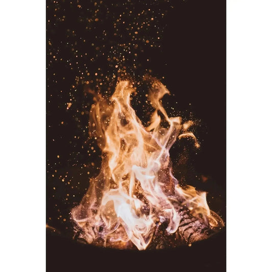 A vibrant golden-orange fire with glowing embers dancing against a dark background for garden fire pit use