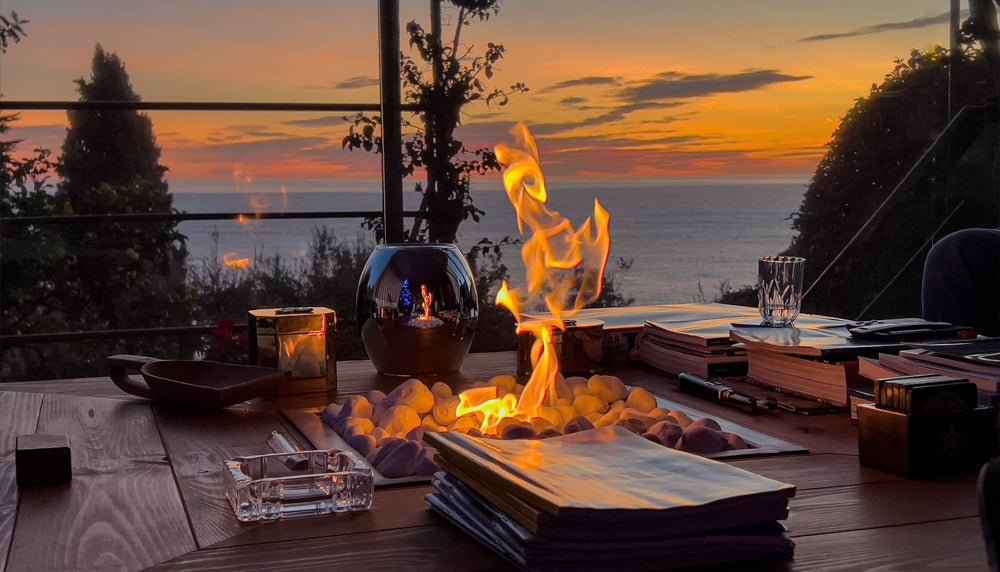A clear glass ashtray with a rectangular design on a wooden table to elevate your establishment with fire.