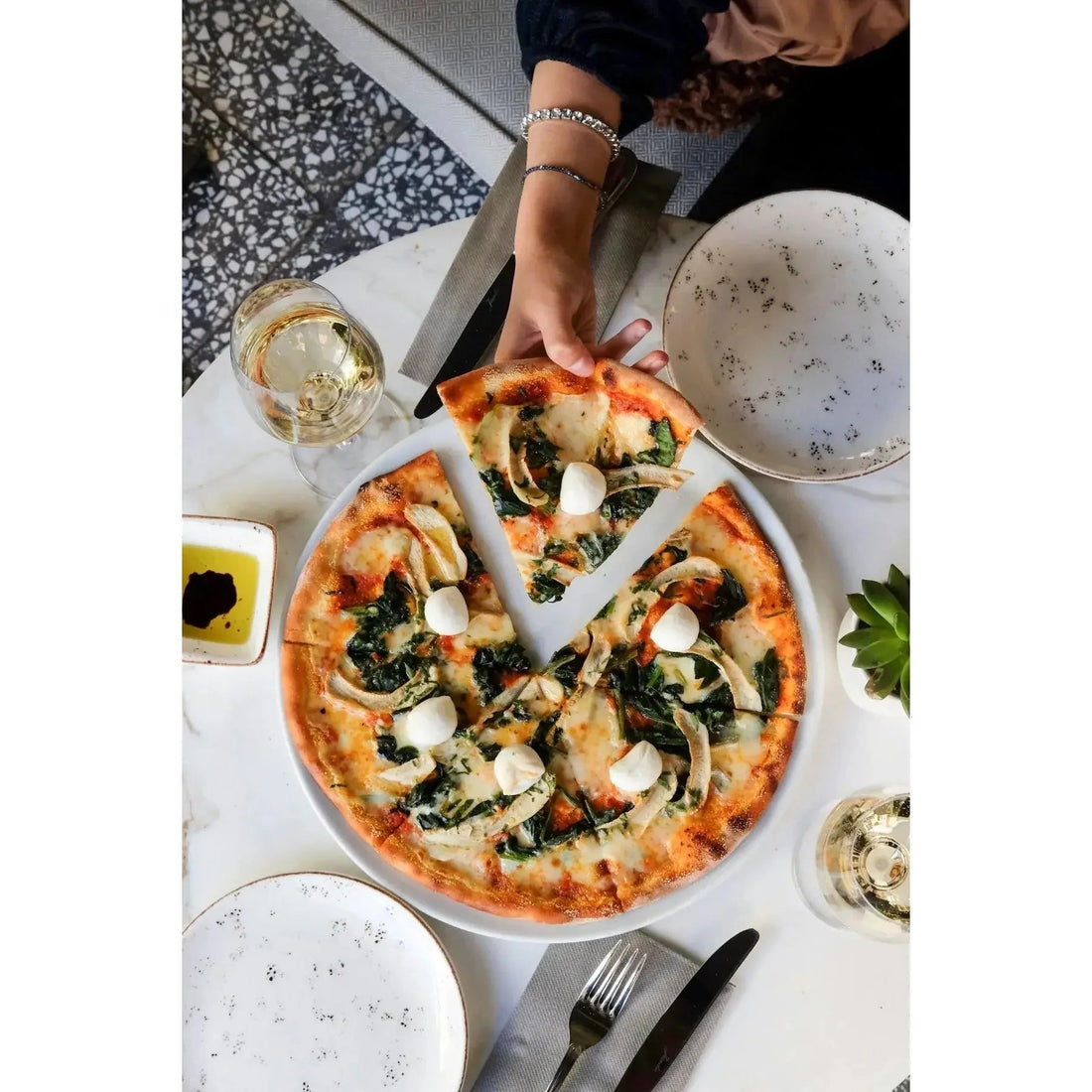 A freshly baked pizza with golden crust topped with spinach mushrooms melted cheese and mozzarella balls for barbecuing history.
