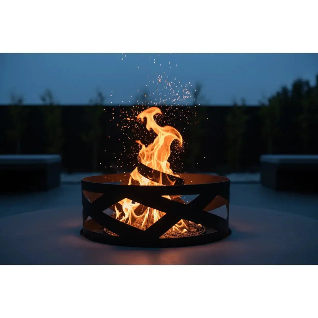 Black metal fire pit with geometric cutout design and glowing orange flames enhancing a garden space