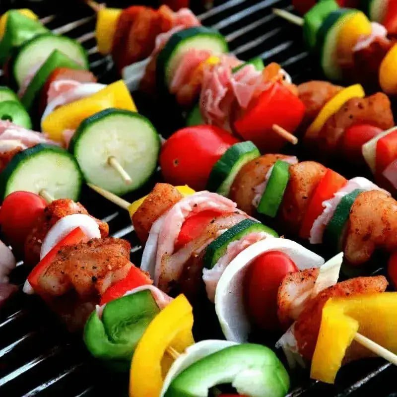 Skewers being grilled over the embers of a charcoal BBQ