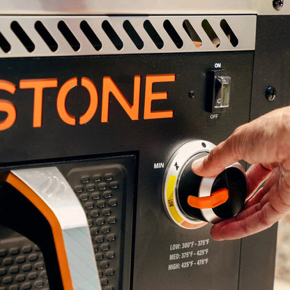 Blackstone 28 inch portable propane grill with black and orange stone body and silver vented panel with orange handle knob