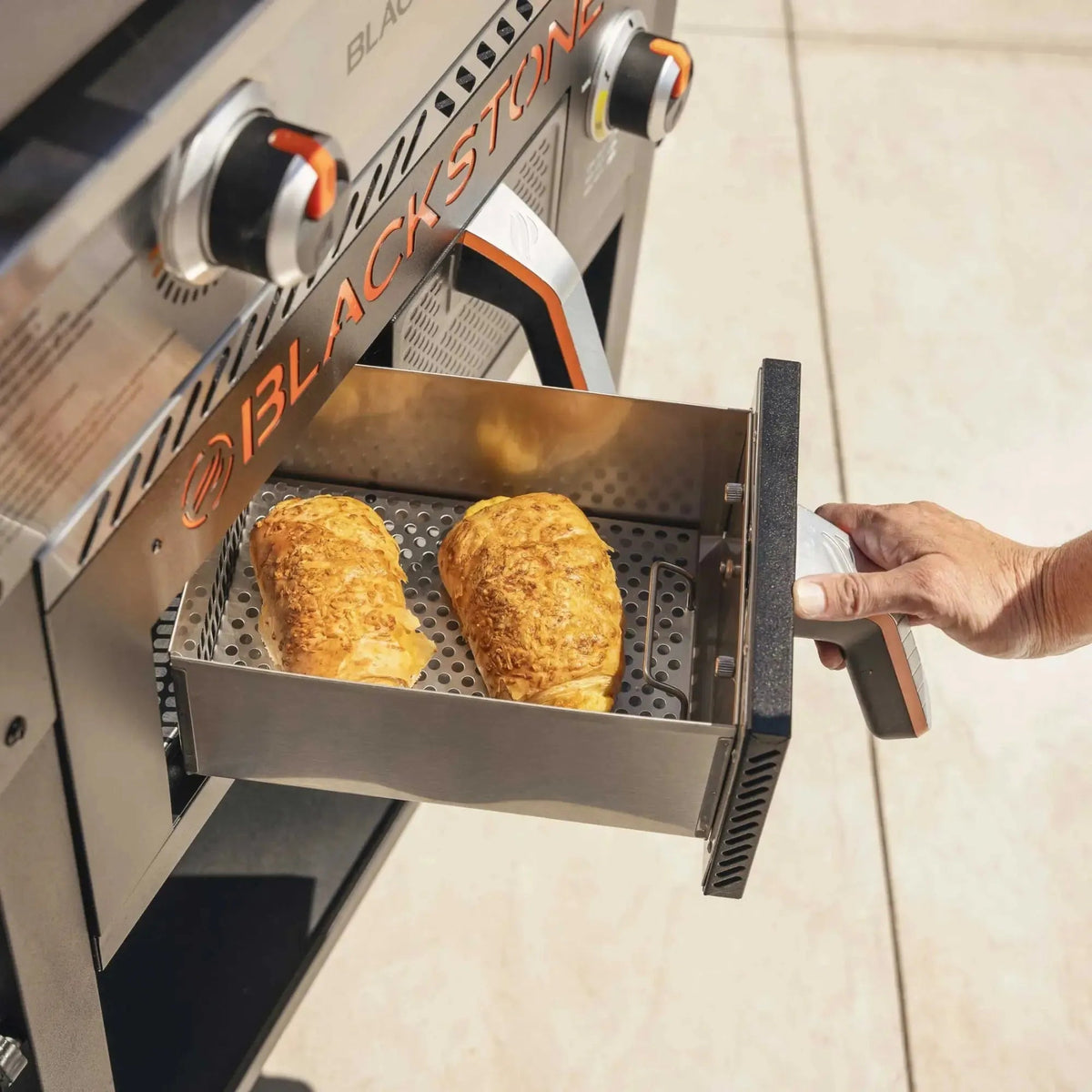 Blackstone 28 inch stainless steel blackstone grill drawer with perforated interior holding baked pastries