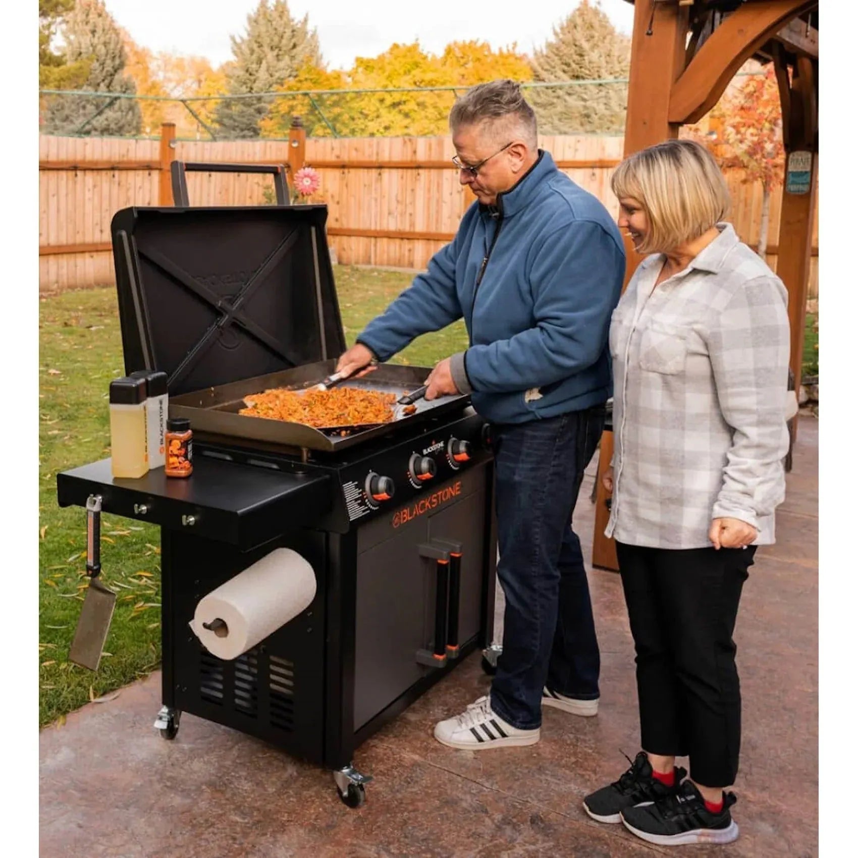 Blackstone culinary 36 inch griddle with flat top cooking surface black exterior and orange control knobs with side table