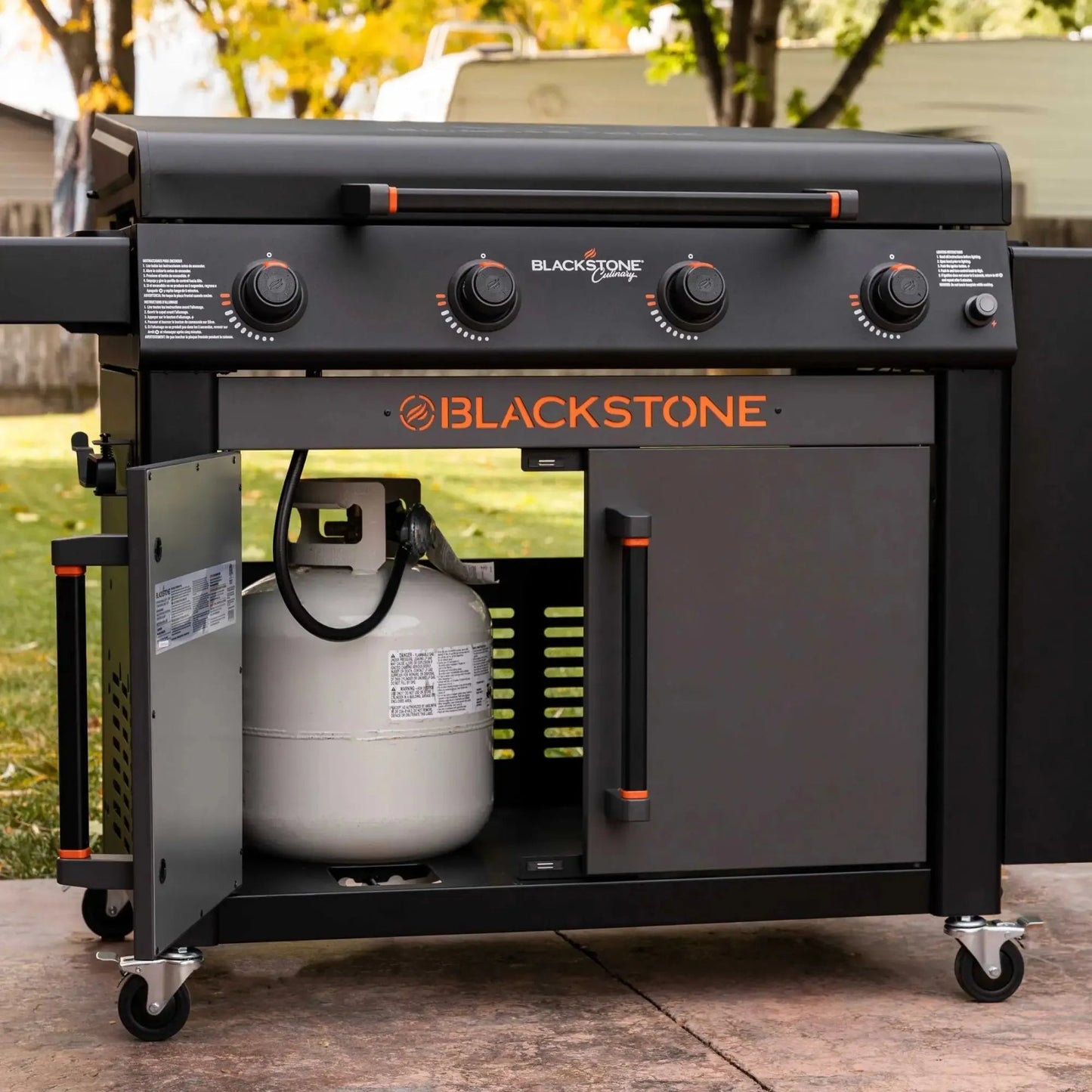 Blackstone culinary 36 inch griddle with cabinet and side table features black body orange branding and control knobs