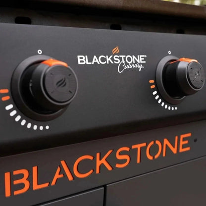 Blackstone culinary 36 inch griddle control panel with black matte finish and orange accents on knobs and branding