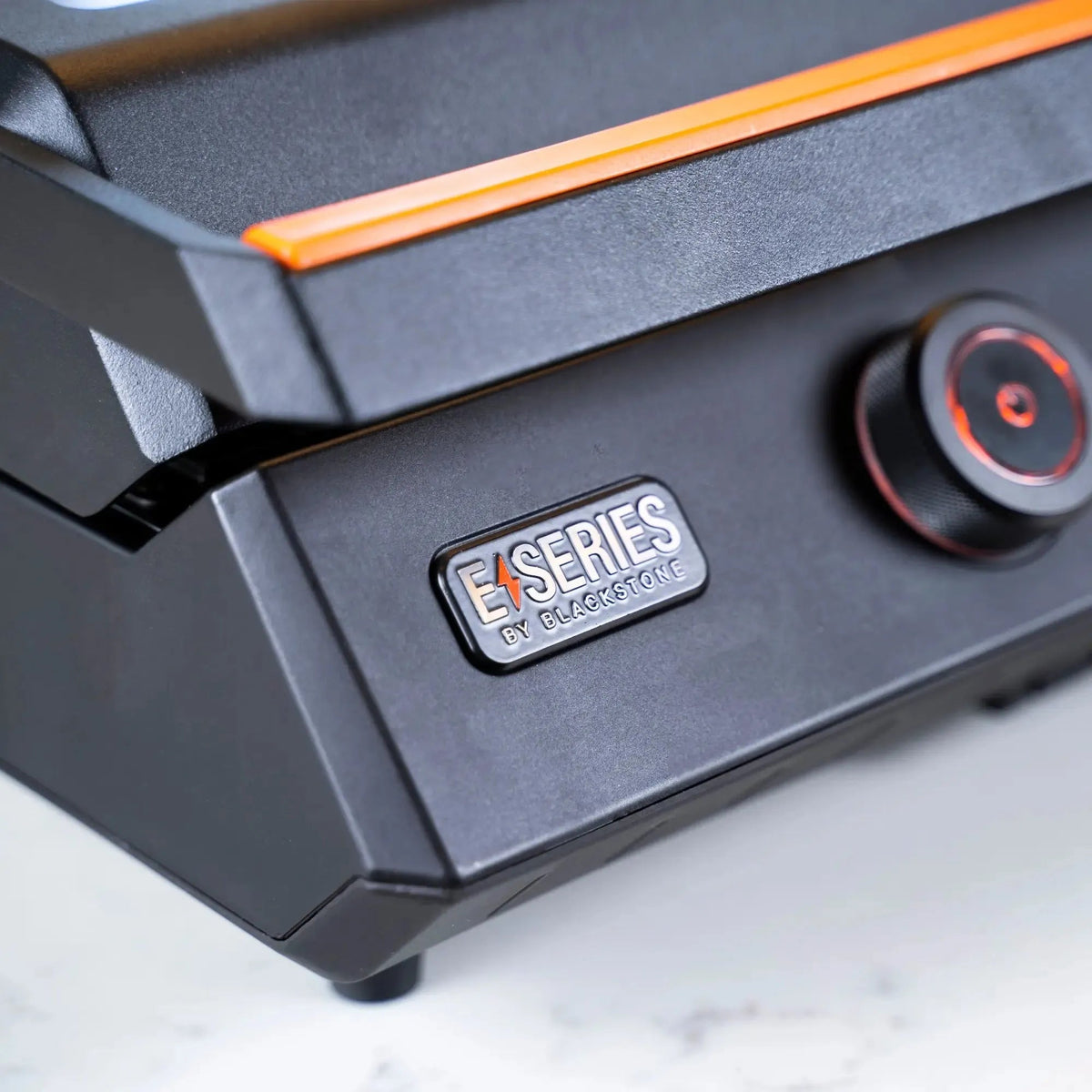 Blackstone e-series 22 inch electric tabletop griddle with black finish orange accent stripe and red-lit control knob