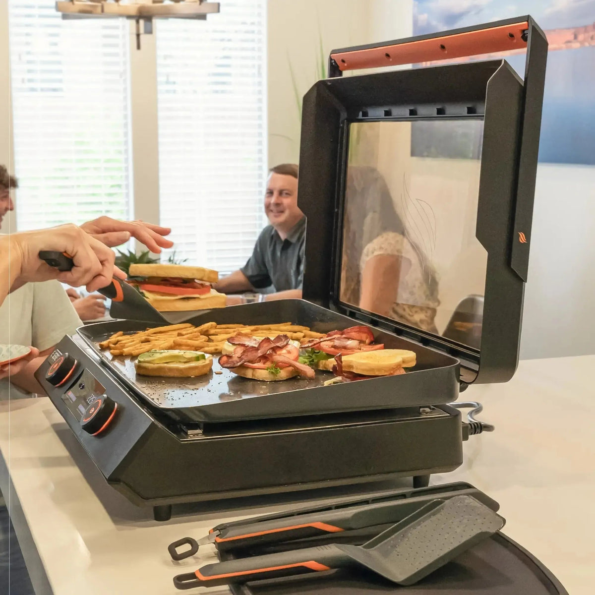 Blackstone E-Series 22 inch black and orange electric griddle with glass lid and multiple cooking zones for bacon eggs fries