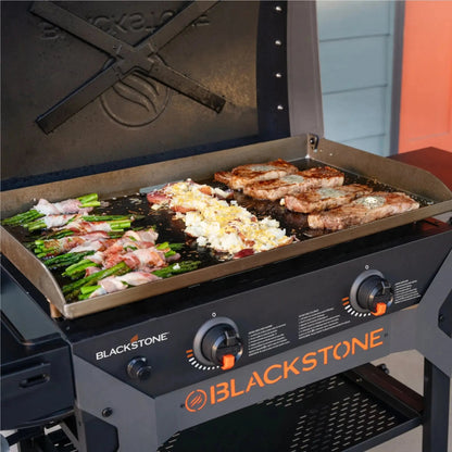 Blackstone iron forged 28 inch gas grill with flat top cooking surface black and orange accents with hood