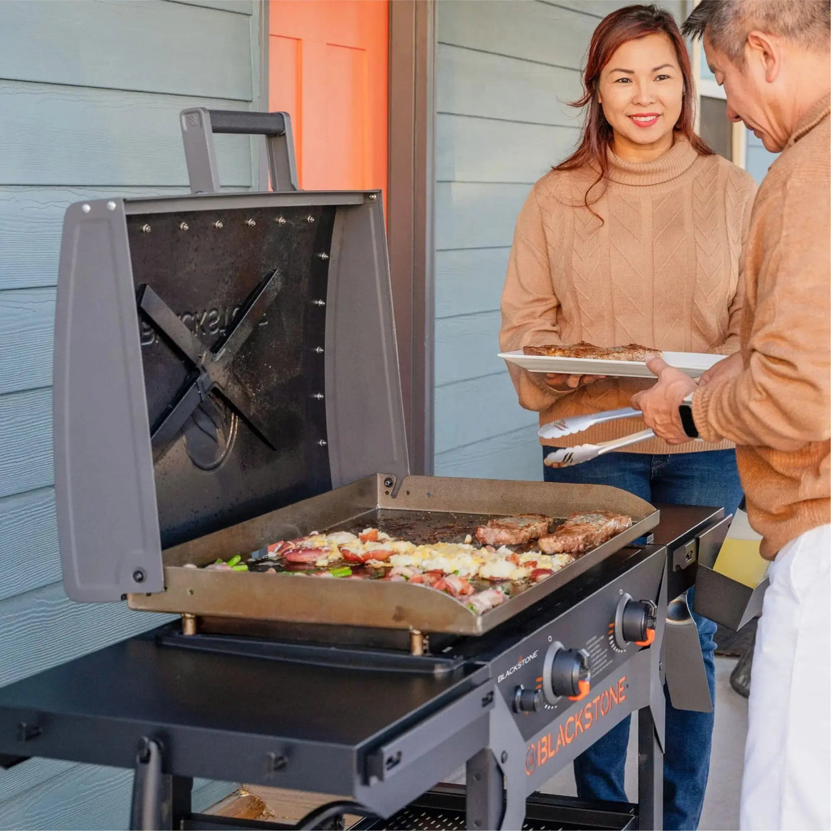 Blackstone iron forged 28 inch gray gas grill with flat-top cooking surface and hinged hood for outdoor cooking