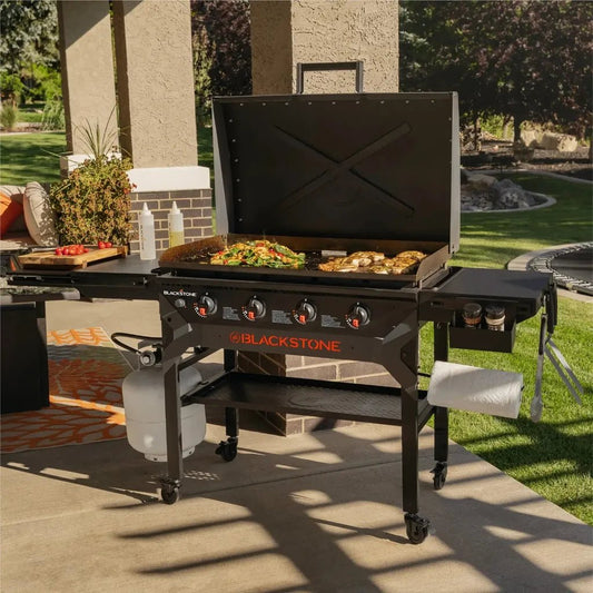 Blackstone iron forged 36 inch griddle with hood featuring a black cast iron surface four burners and orange branding