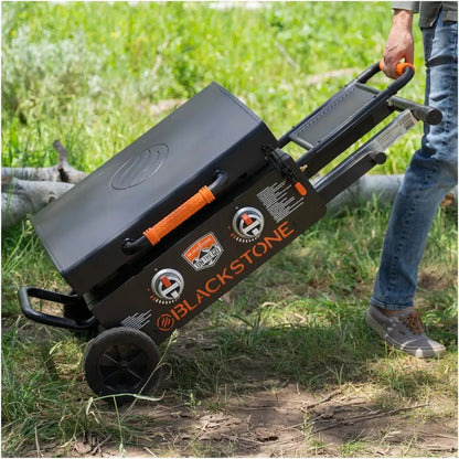 Blackstone otg 22 inch griddle with black body orange handle and wheels on a wheeled cart for easy mobility