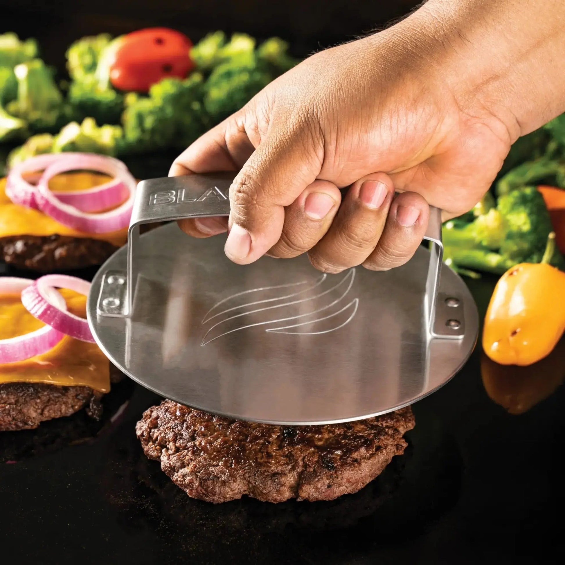 Stainless steel blackstone smash burger press with sleek modern design and engraved logo in a 3-piece kit