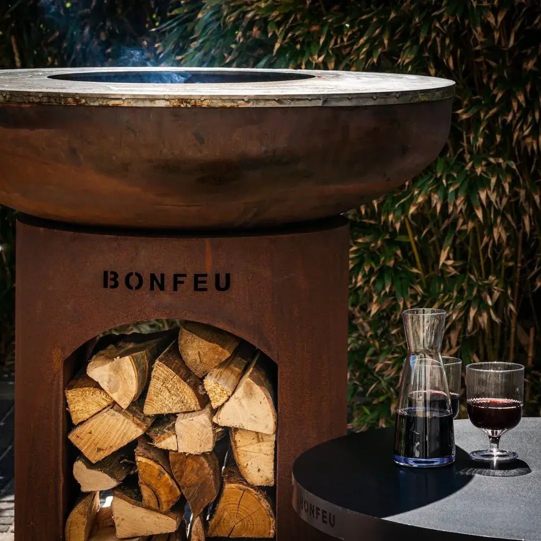 Rustic brown corten steel bonfeu bonbiza open plancha grill fire pit with circular top and stacked wood inside