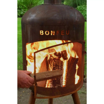 Rusty metal bonfeu bonbono large outdoor fireplace with mesh screen and glowing flames in corten steel