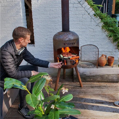 Rustic bonfeu bonbono large outdoor fireplace in black metal with tripod legs and chimney grilling food in open front