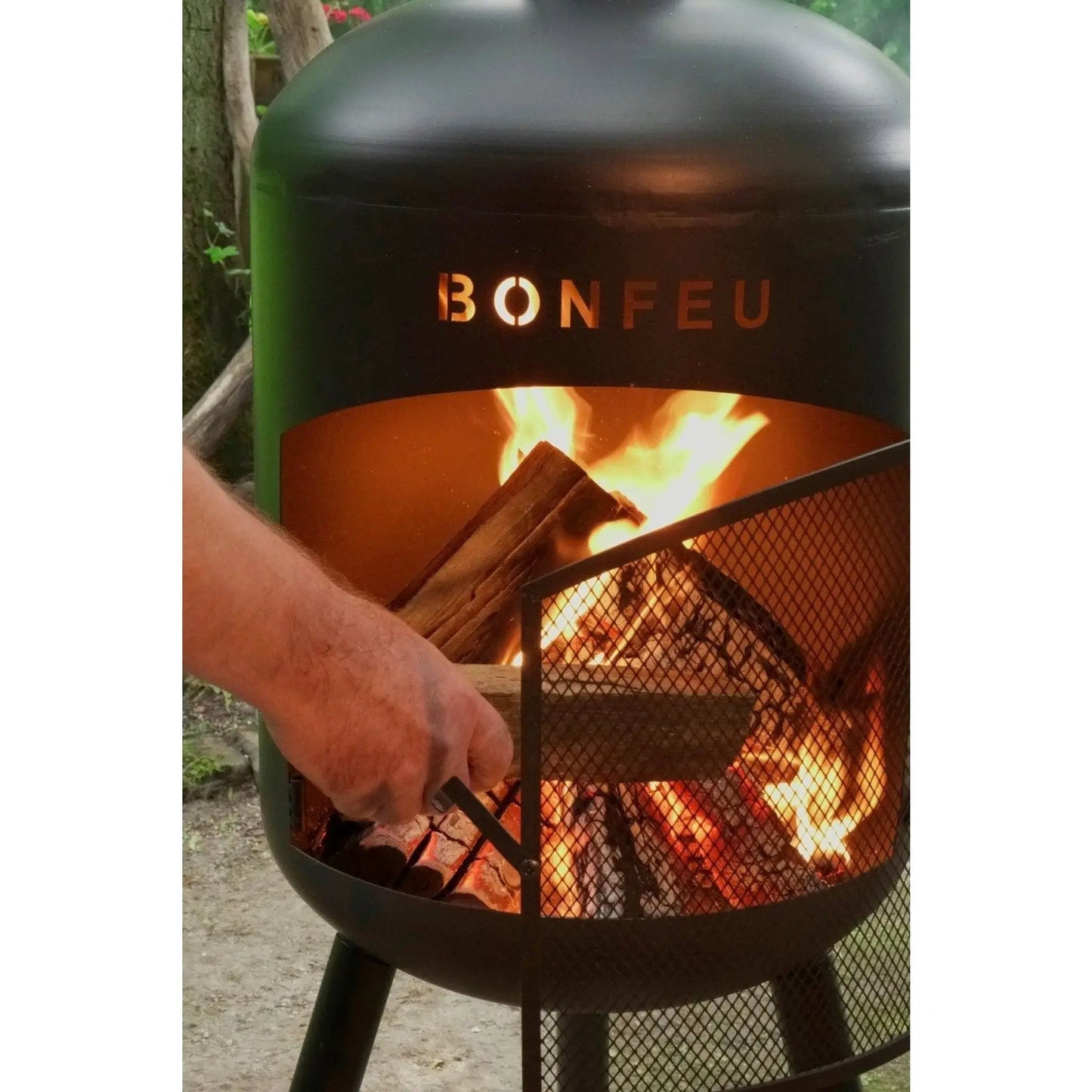 Black metal bonfeu bonbono large outdoor fireplace with mesh screen and glowing embers inside