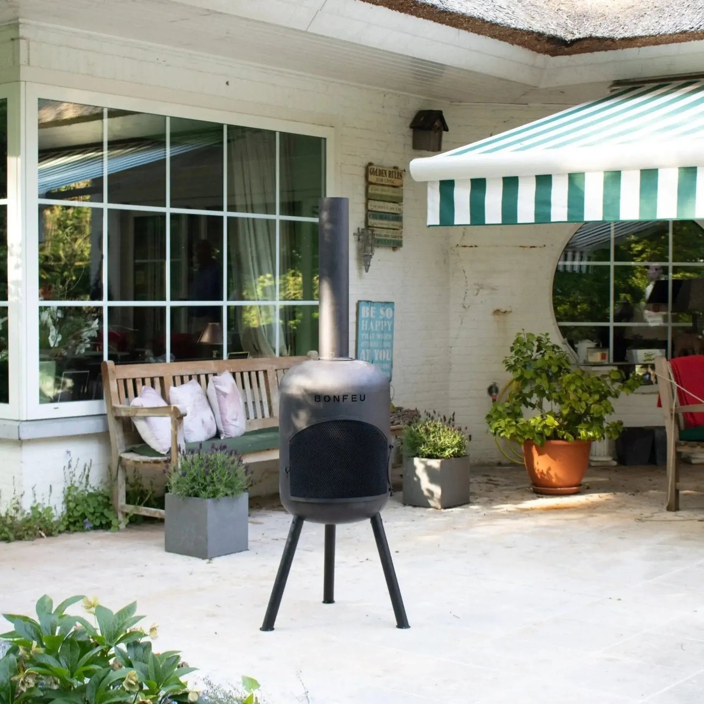 Black metal bonfeu bonbono large outdoor fireplace with cylindrical body tripod legs and vertical chimney
