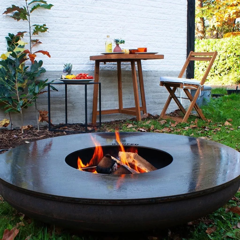 Black steel bonfeu bonbowl fire pit with circular design and visible flames inside for outdoor use