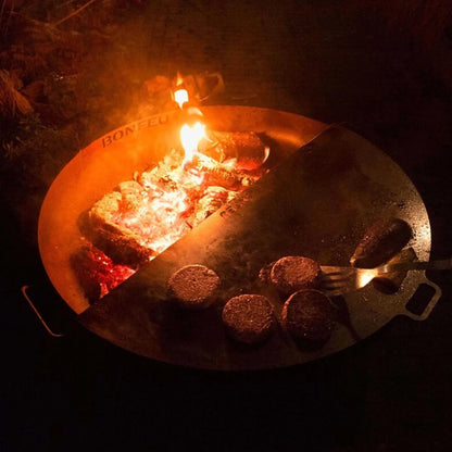 Bronze corten steel bonfeu bonbowl plus fire pit with split design showing embers and cooking burger patties