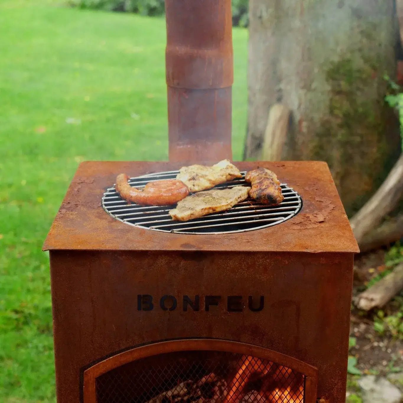 Rustic copper corten steel bonfeu boncarré outdoor fireplace with circular black wire grate and engraved brand name front