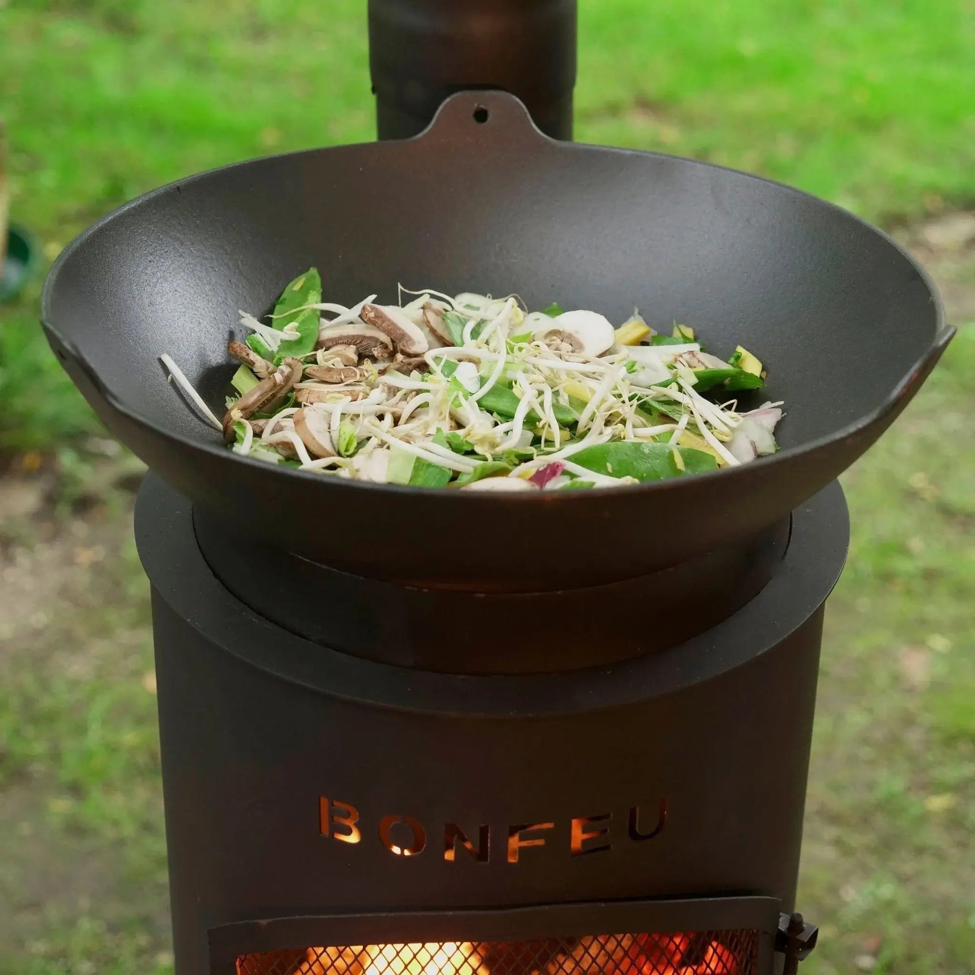 Black cast iron wok with stir-fry on bonfeu bongiano lp black and corten steel outdoor wood-burning stove