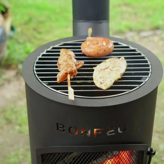 Black bonfeu bongiano lp cylindrical outdoor fireplace with metal grate and visible fire inside made of steel