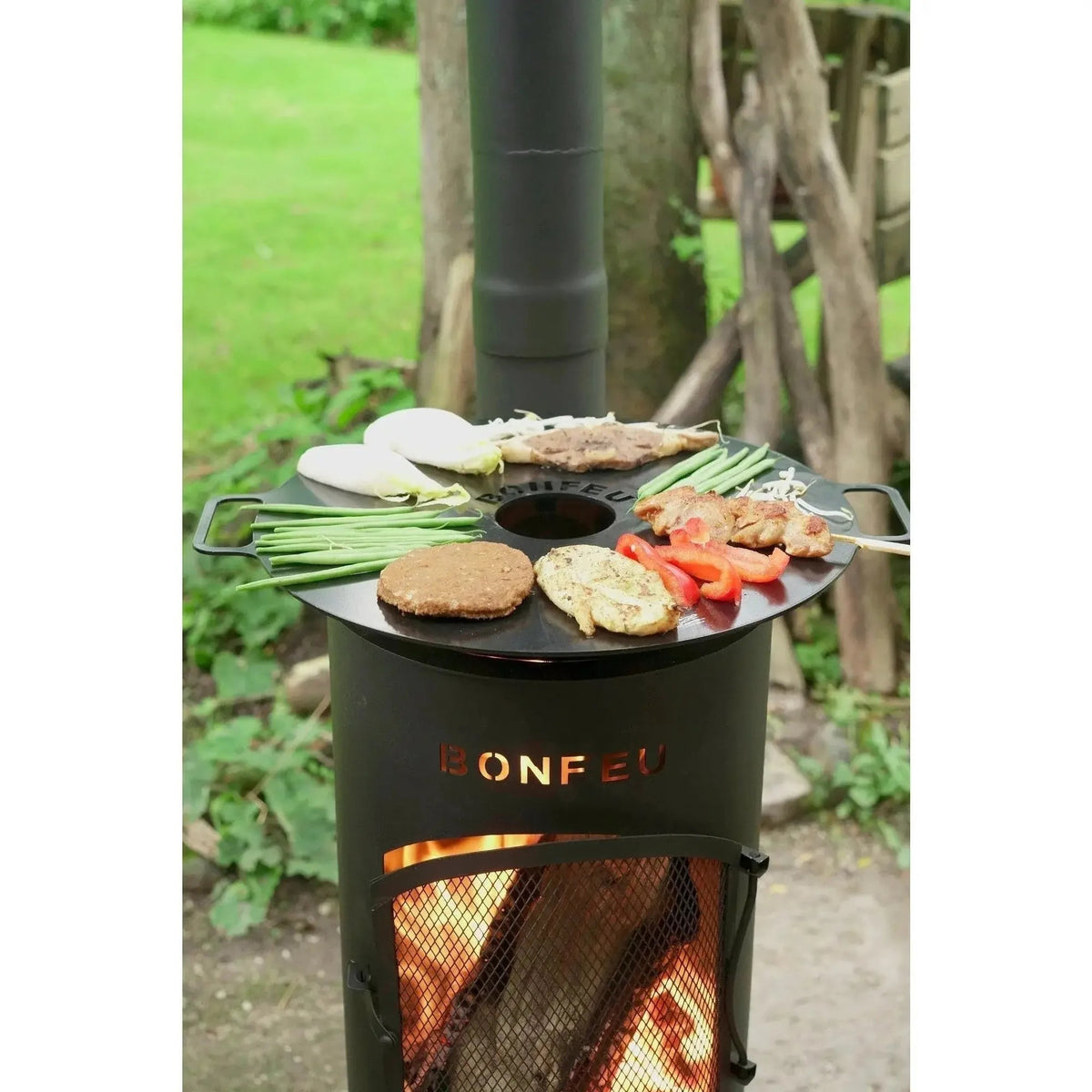 Black bonfeu bongiano sp outdoor fireplace with round cooking surface and visible flames in black and corten steel