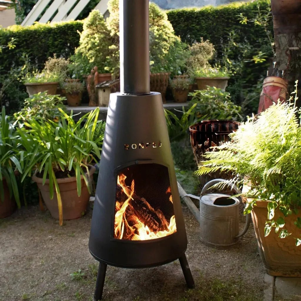 A sleek matte black bonfeu bonpyra large outdoor fireplace with tall chimney and three sturdy legs