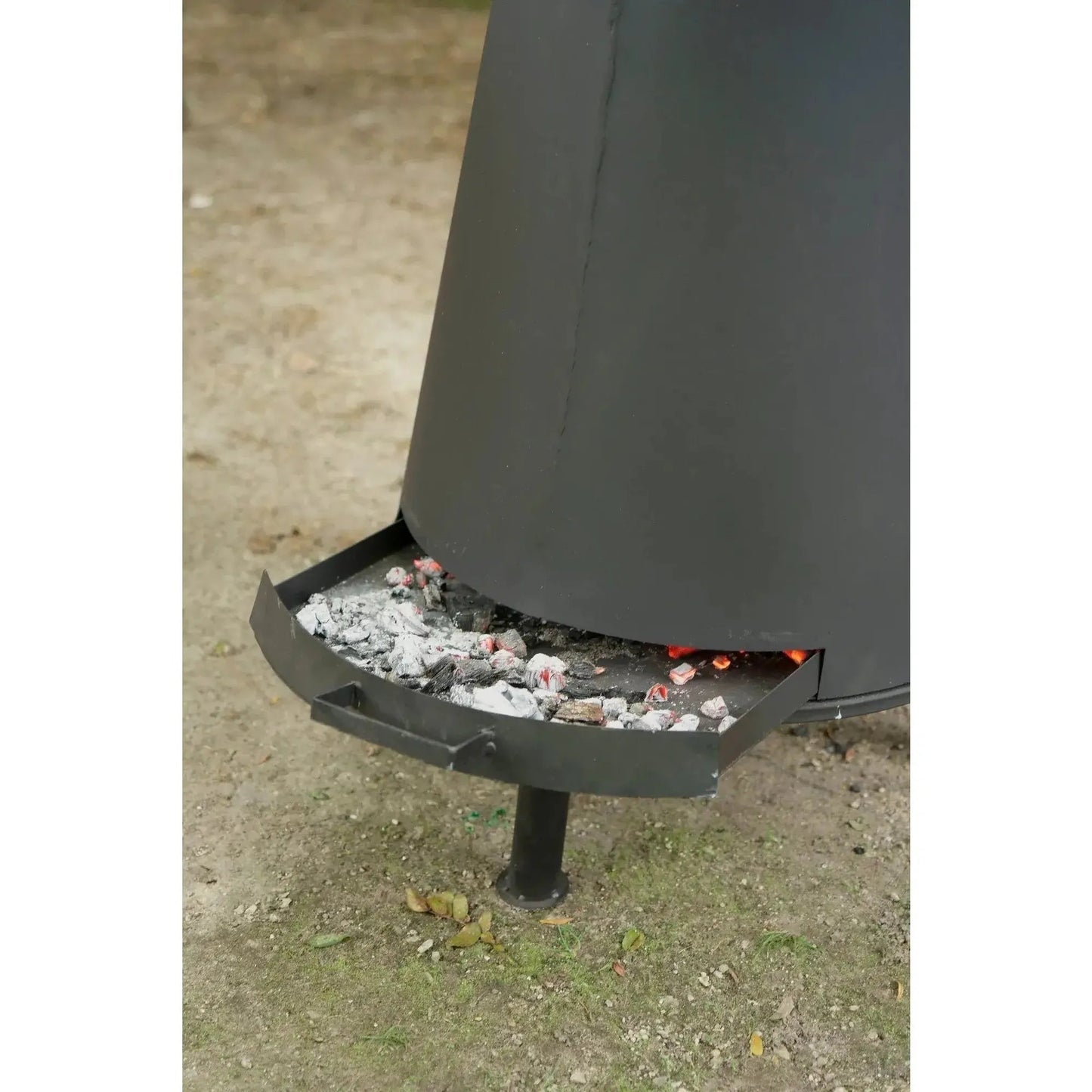 Black metal BonFeu BonPyra large outdoor fireplace with ash tray and glowing embers inside