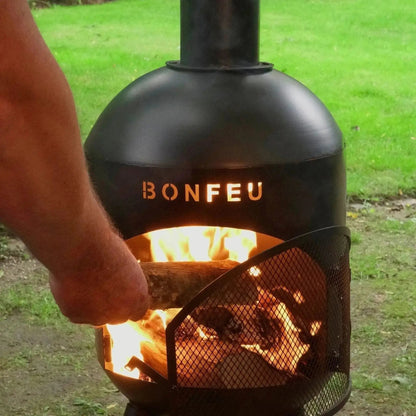 Black bonfeu bonsolo outdoor fireplace metal fire pit with mesh screen and glowing flames inside