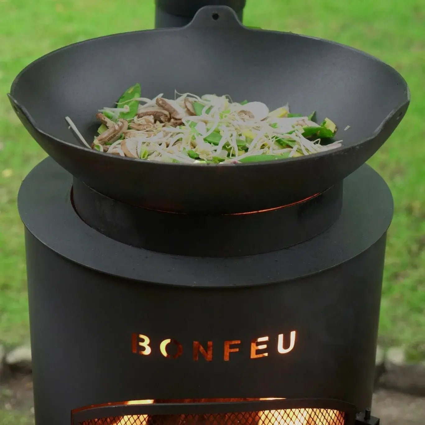 Black cast iron wok resting on bonfeu bontino lp outdoor fireplace stove in black for outdoor cooking