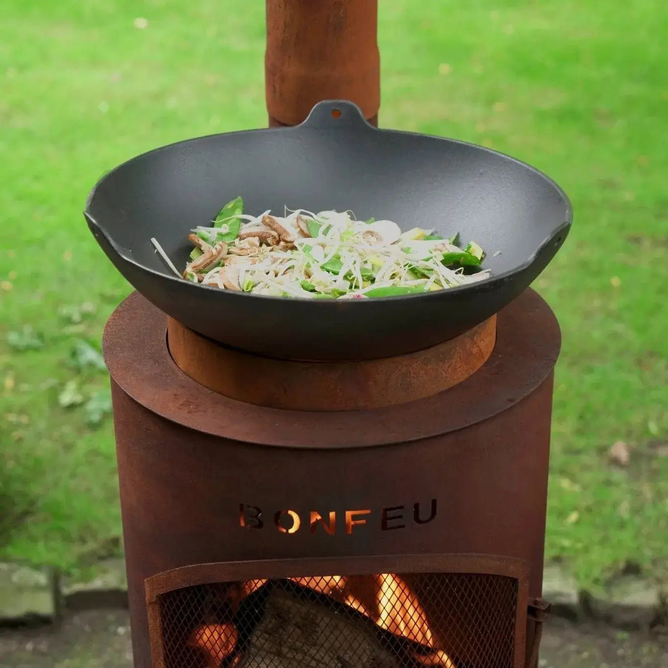 Black cast iron wok on rust-colored corten steel bonfeu bontino lp outdoor wood-burning stove fireplace
