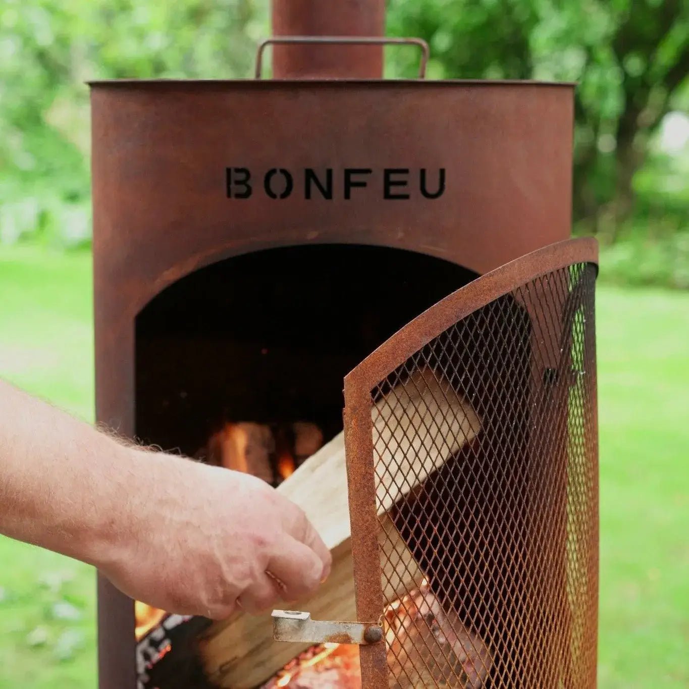Rust-colored corten steel bonfeu bontino lp outdoor fireplace with mesh screen and bonfeu branding