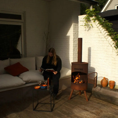 Rust-colored corten steel bonfeu bonton large outdoor wood-burning stove with tall chimney and dorfed brand on front