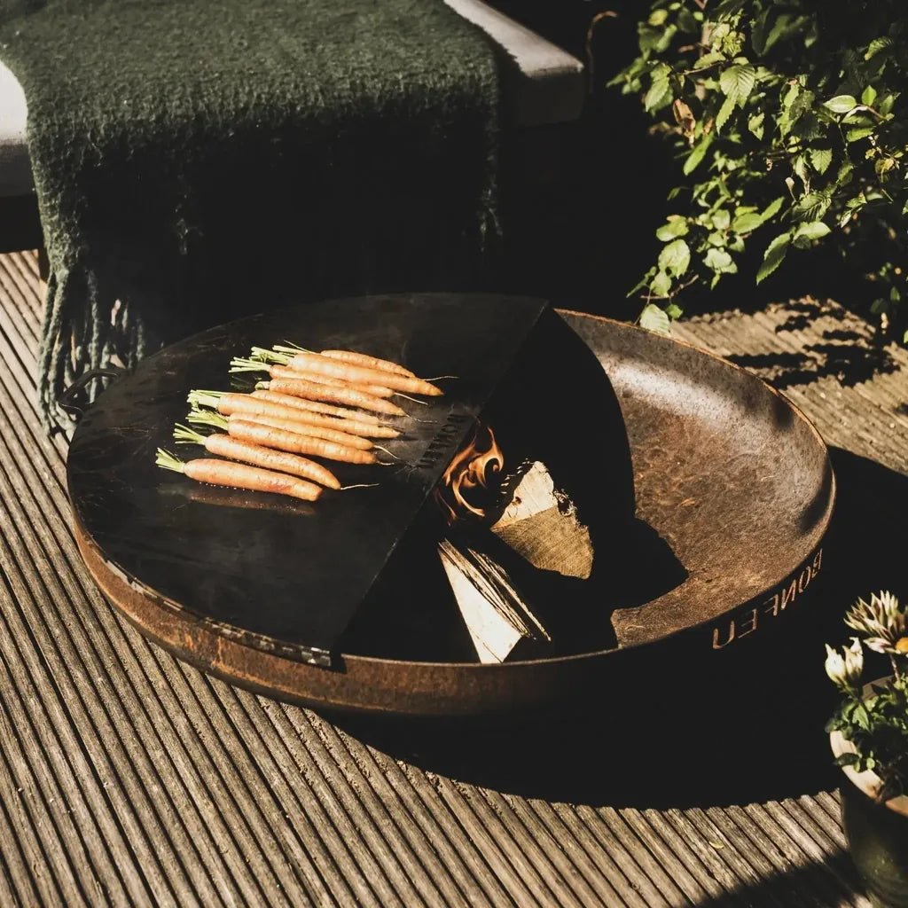 Rustic bronze bonfeu plancha fire pit with black interior and wood stack for bonbowl fire bowls use