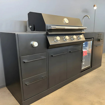 Stainless steel gas grill with black accents and four control knobs on dark gray brabura lite maxi 4 outdoor kitchen unit