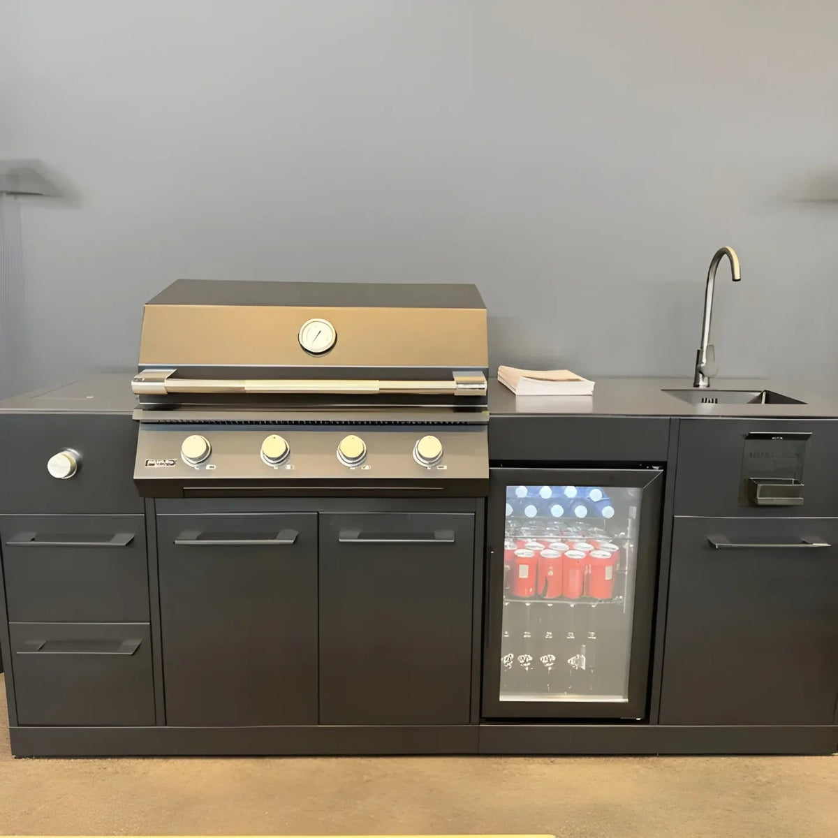 Stainless steel gas grill with four control knobs and temperature gauge built into dark gray brabura lite maxi 4 outdoor kitchen unit