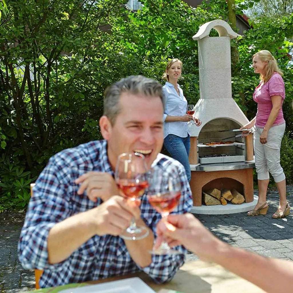 Buschbeck Davos masonry barbecue is a stone and wood outdoor pizza oven with an arched top and built-in grill