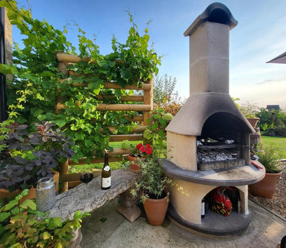 Beige stone buschbeck verona masonry barbecue with curved chimney and built-in grill for outdoor cooking