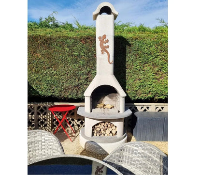 Beige stone outdoor fireplace buschbeck verona masonry barbecue with copper lizard design arched opening and firewood compartment